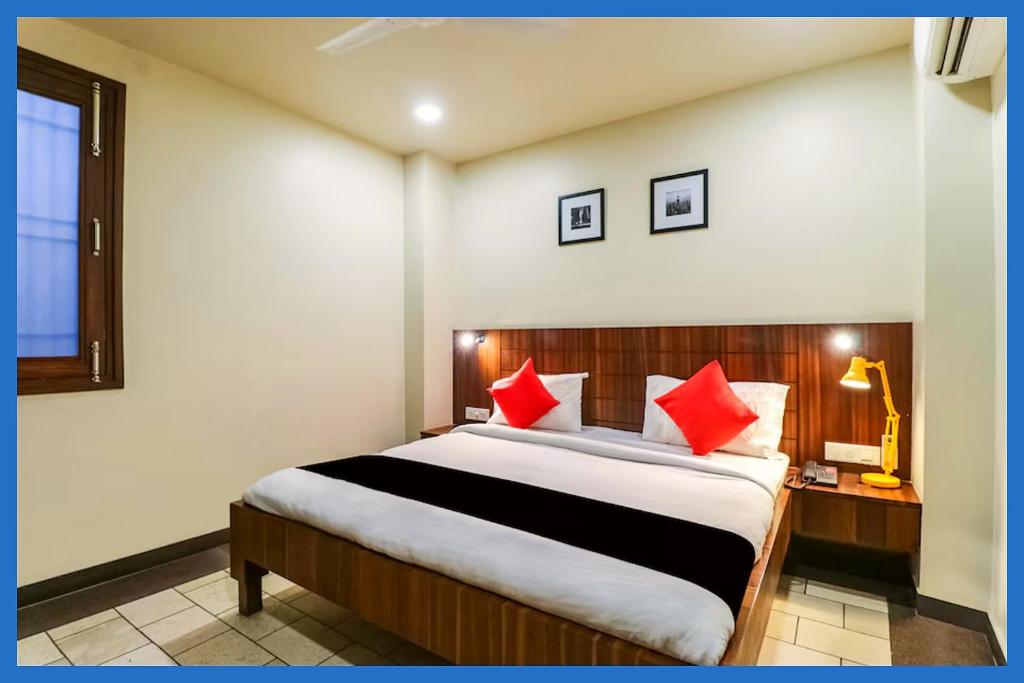 une chambre avec un grand lit avec des oreillers rouges dans l'établissement Hotel Kavyani Sidhant Palace Near Kashi Vishwanath Temple - Free Wifi and Free Parking Facilities - Free Wifi Facilities # Fully Air conditioning Luxuary Room - Top Rated Hotel In Varanasi, à Varanasi