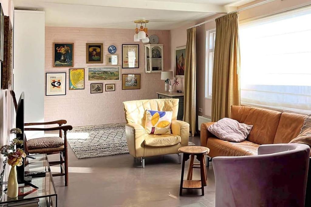 un salon avec un canapé et une chaise dans l'établissement Lovely Studio with Patio and Garden, à Westenschouwen