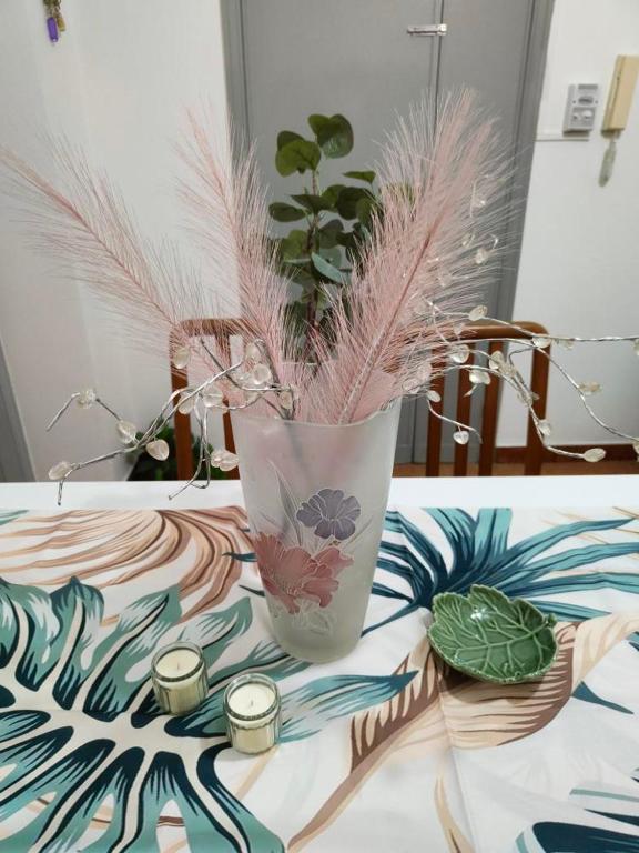 a vase with some plants in it on a table at Vittorio Emanuele Central Apartment in Letojanni