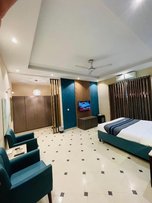 a hotel room with a bed and a chair at Shelton Rezidor House F-8 Islamabad in Islamabad