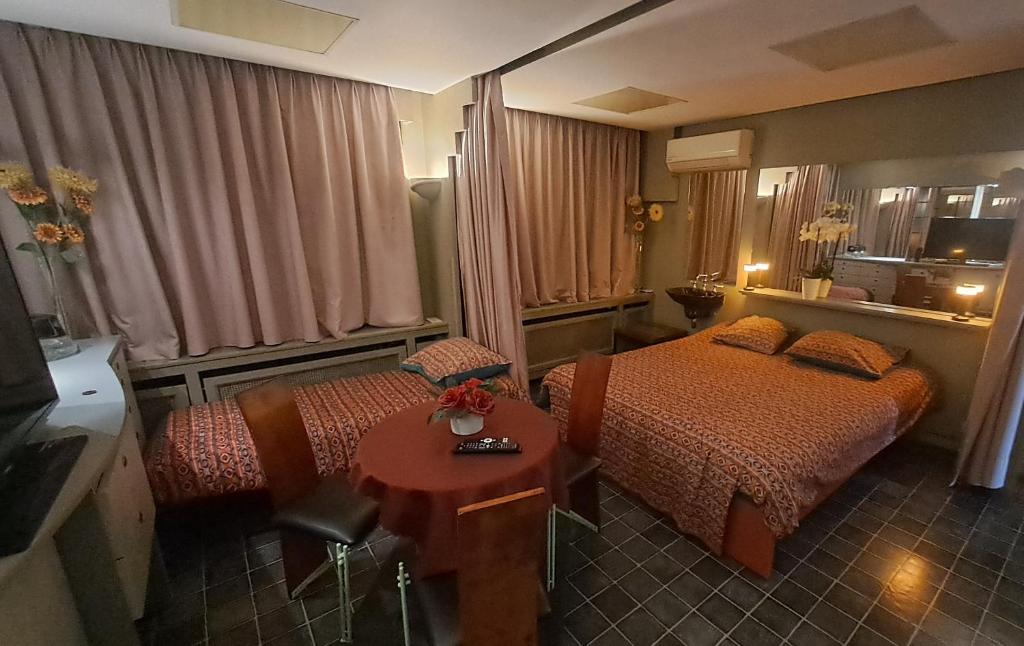 a hotel room with two beds and a table at BeautyD FAMILY ROOM with max 1 child centrum GULLEGEM KORTRIJK in Gullegem