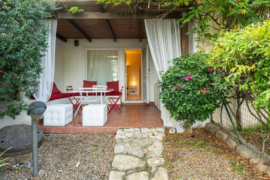 une maison avec un patio avec une table et des chaises dans l'établissement Villa Amaranta - Is Molas, à Is Molas 