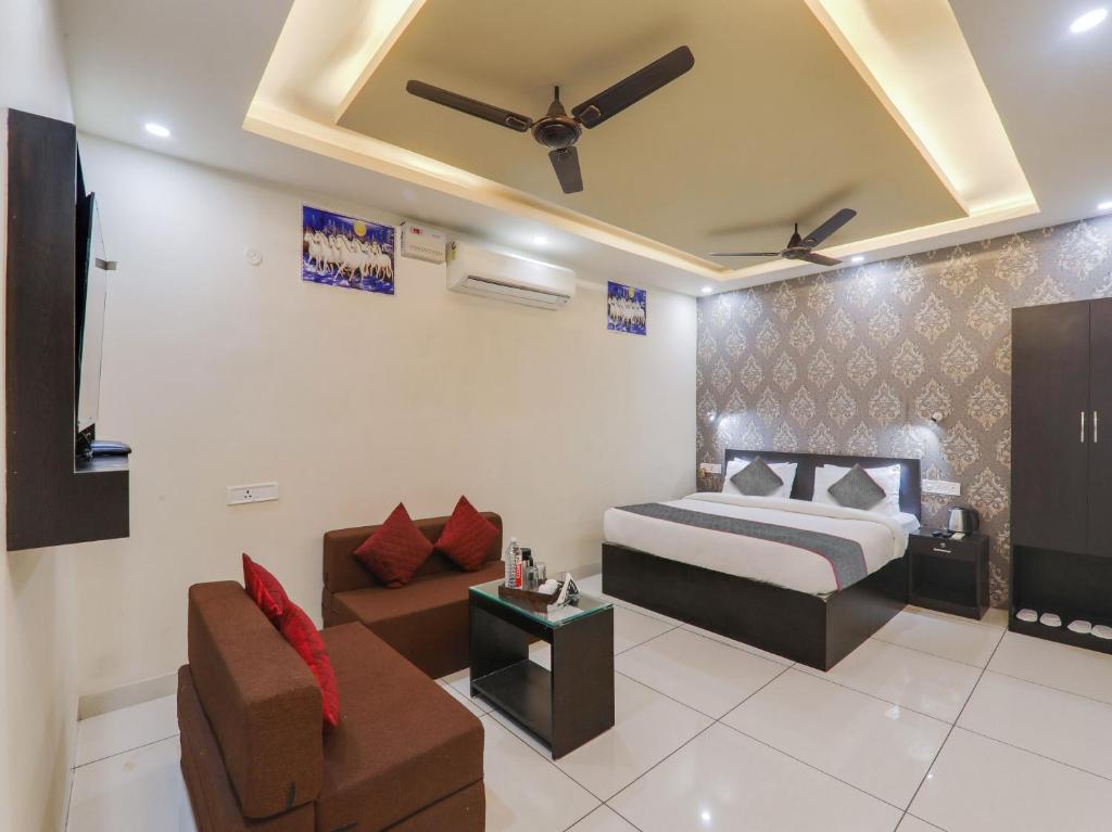 a hotel room with a bed and a couch at Super Hotel O Centrum in Gorakhpur