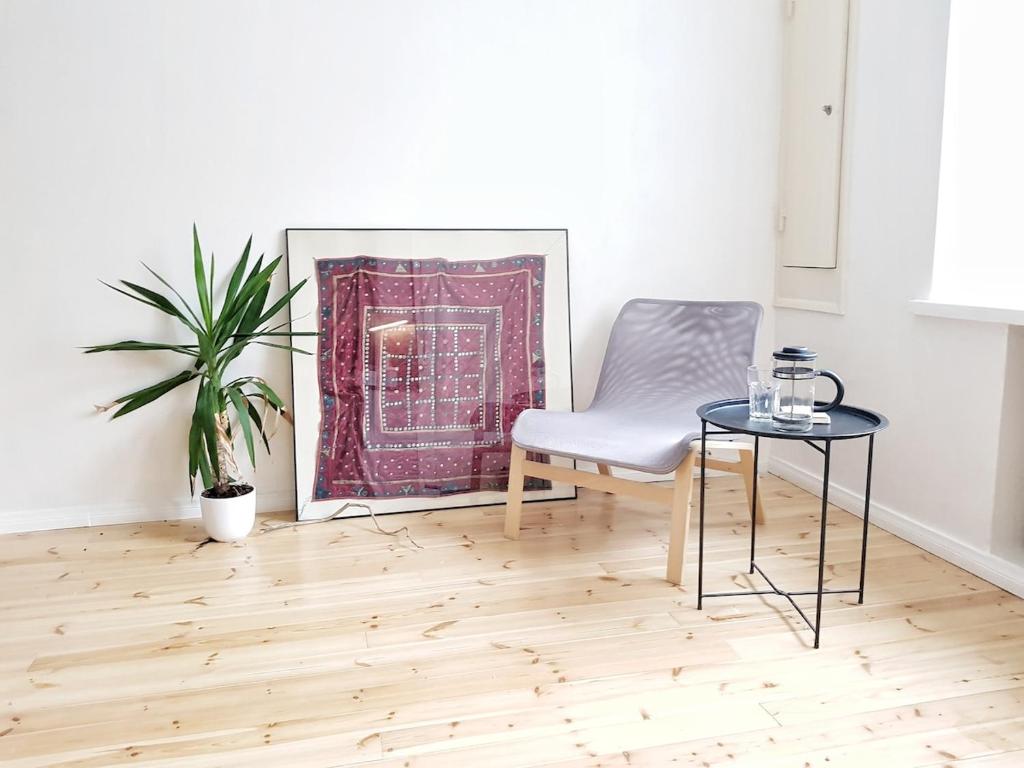 a living room with a chair and a table at Harjutori Studio Flat, A quiet park close to the city centre and the airport in Helsinki