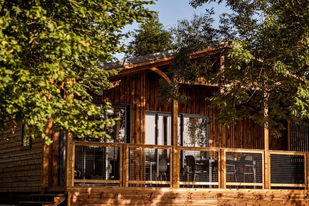 a log cabin with a screened in porch at Chalet confort, Proche Puy duFou, plan d'eau privé in Menomblet