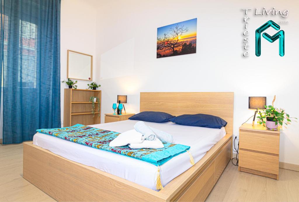 的里雅斯特Trieste LIVING的卧室里有一张床，床上放着两条毛巾。