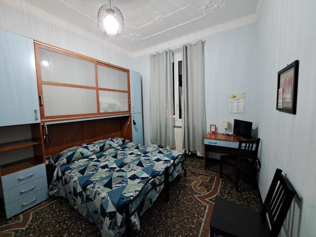 a bedroom with a bed and a desk with a computer at BB Sextum in Genoa