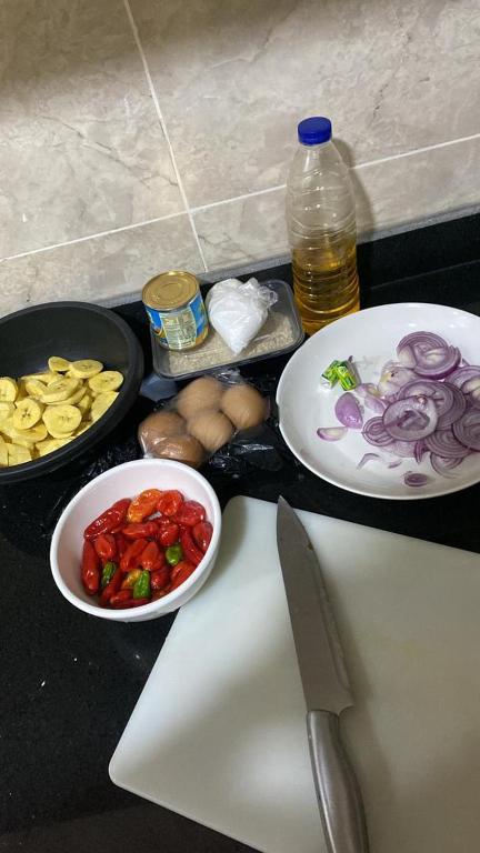 una encimera con dos platos de comida y un cuchillo en AIN LUXE Stay, en Idogwari