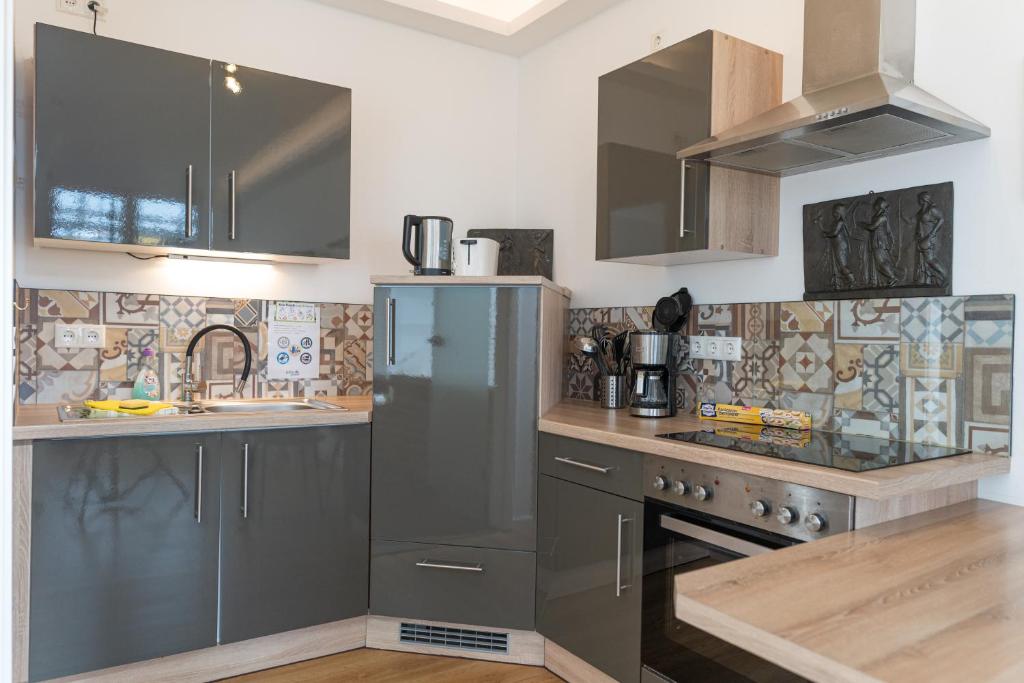 a kitchen with stainless steel appliances and tiles at Kara Ben Nemsi in Ilmmünster
