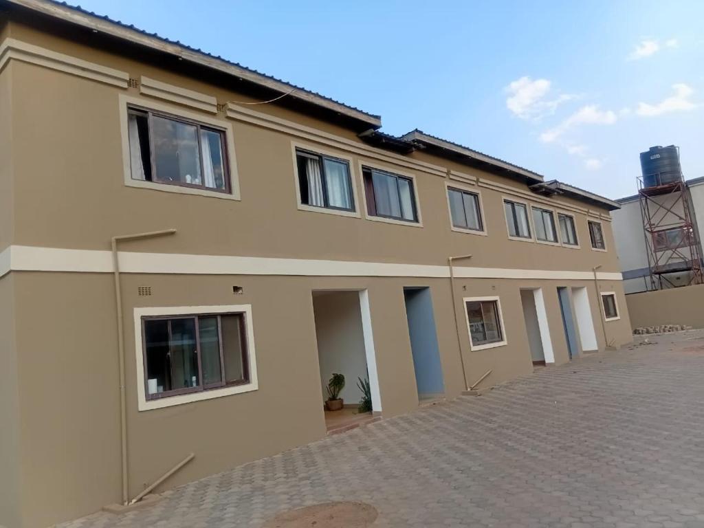 una grande casa con un vialetto d'accesso davanti di ThandyTasha luxury apartments a Lusaka
