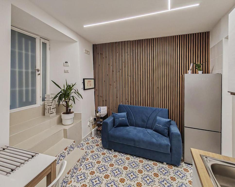 a blue chair in a room with a kitchen at Casa Del Duca in Salerno