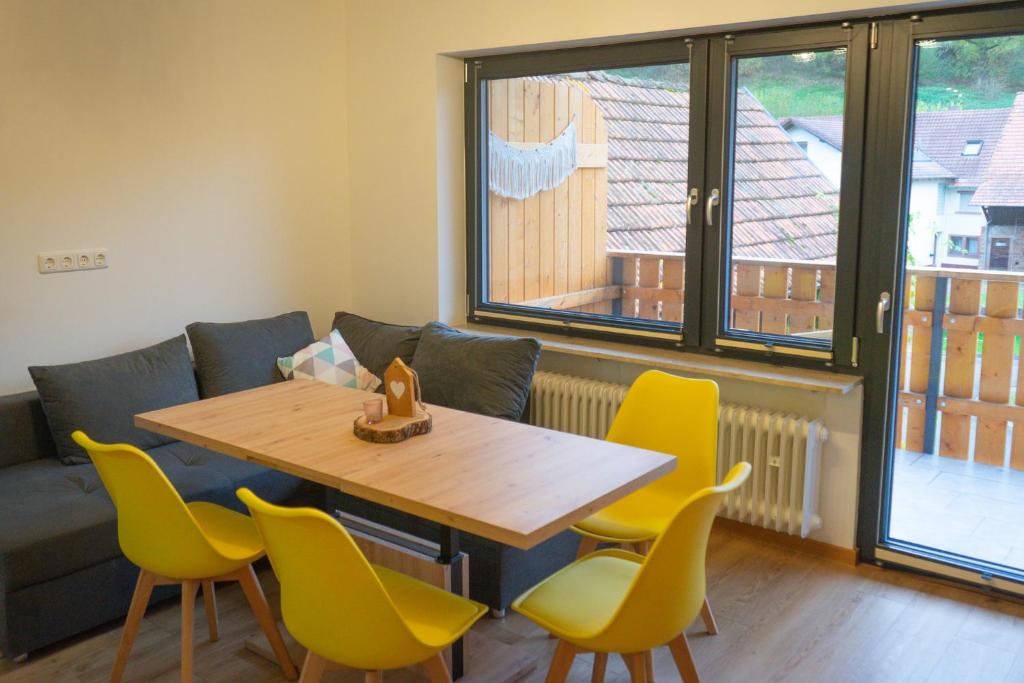 a dining room with a table and yellow chairs at Ferienwohnung Feuer im Ferienhaus am Waldbach in Kirchzell