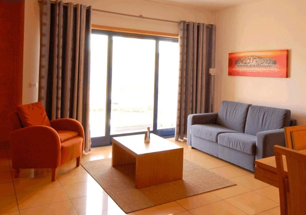 ein Wohnzimmer mit einer Couch und einem Couchtisch in der Unterkunft Charming Orada 2-Bedroom Albufeira Duplex Apartment with Shared Pool sleeps 6 in Páteo