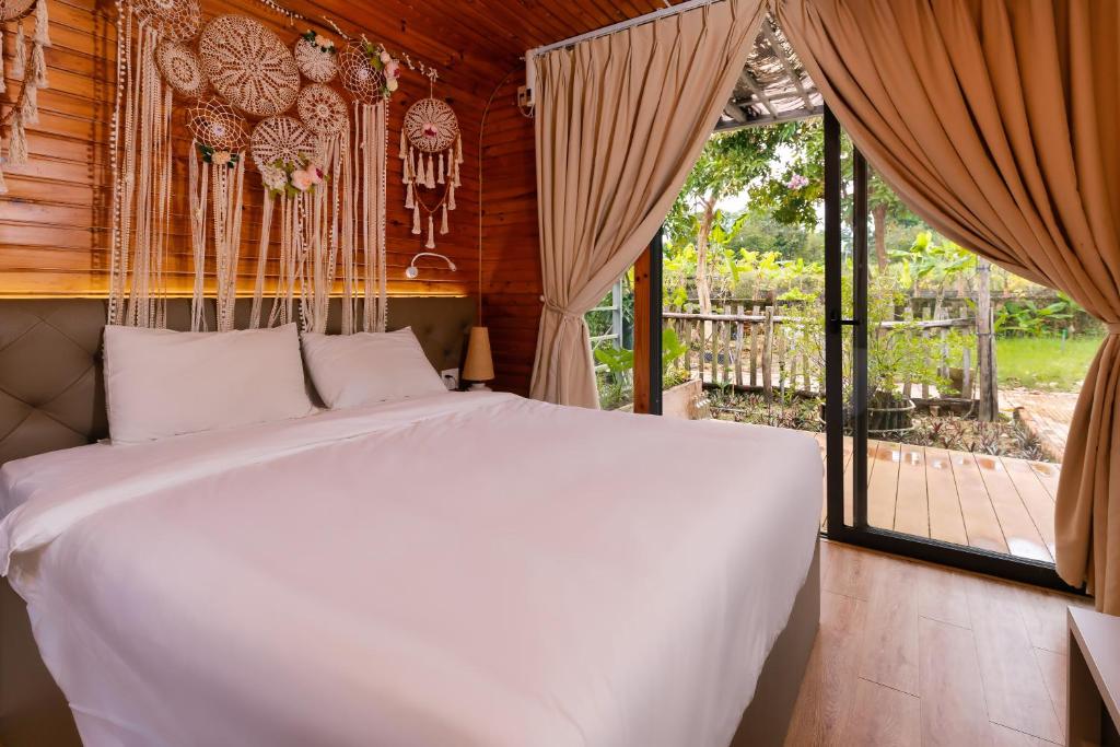ein Schlafzimmer mit einem weißen Bett und einem Fenster in der Unterkunft Sim Resort in Phu Quoc