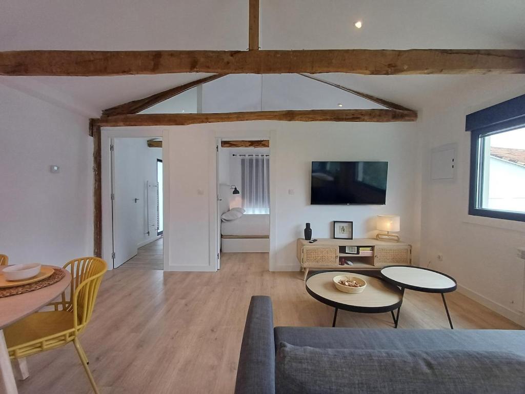 ein Wohnzimmer mit Sofa und Tisch in der Unterkunft Villa La Marquesa - amplia, con patio y barbacoa in Ourense