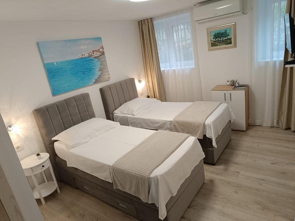 une chambre d'hôtel avec deux lits et une fenêtre dans l'établissement Apartments Maraton, à Split