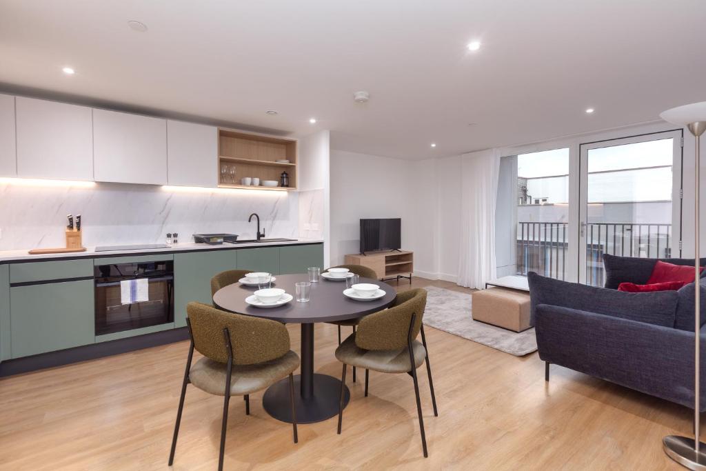 a kitchen and a living room with a table and chairs at Orchard by UTDM in Bristol