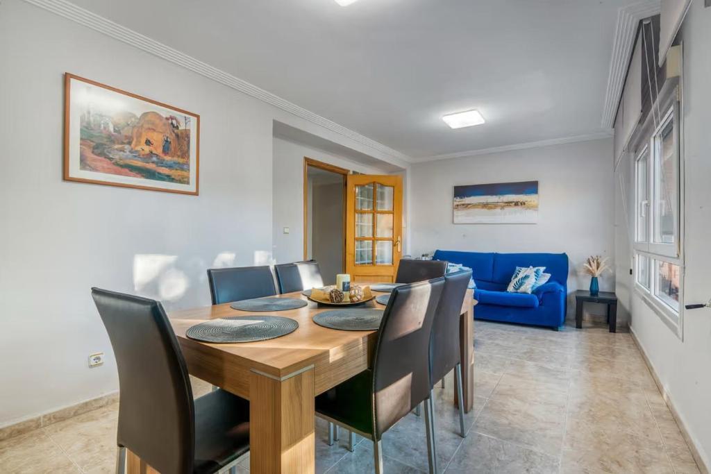a dining room with a table and a blue couch at CaTere Estancia Bocairent in Bocairent