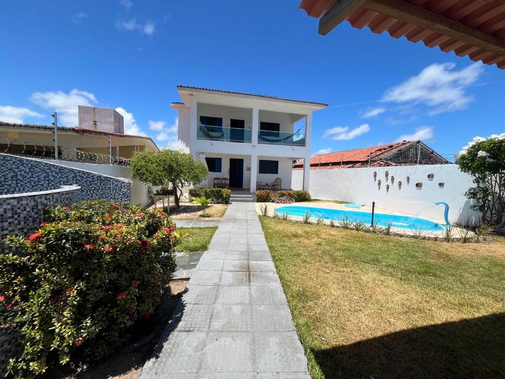eine Villa mit Swimmingpool und ein Haus in der Unterkunft Casa vista Mar, pé na areia com piscina ! in Pitimbu