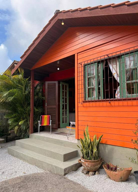 a red house with a dog sticking its head out the window at Casinha Encantada-Café Cacupé Hospedagem in Florianópolis