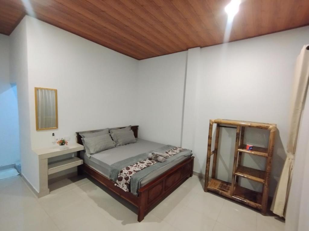 a small bedroom with a bed and a mirror at Ilham Homestay in Kuta Lombok