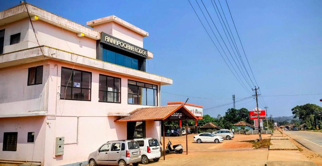 a building with cars parked in front of it at Annapoorna lodge agumbe in Someshwar