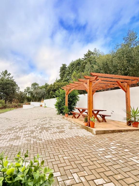 a wooden pavilion with picnic tables on a patio at Monte do Garnacho - Villa in the Mountains in Sertã