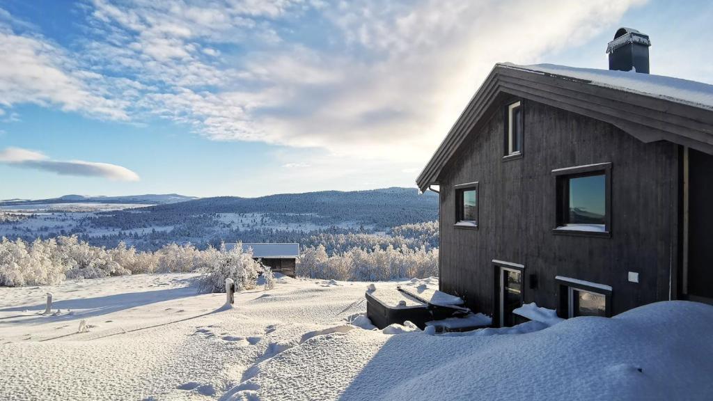 a building with snow on the ground next to a building at Simple Cabin Life In This Nature Cabin in Uvdal