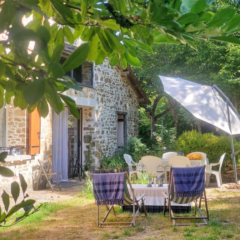a table and chairs in front of a house at Gîte de plain-pied sans escaliers, Dordogne in Firbeix