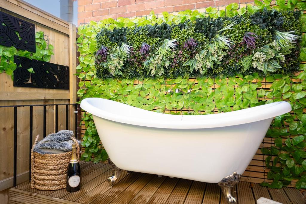 a bathroom with a green wall with a bath tub at Northern Hideaways, The Nest Ponteland in Newcastle upon Tyne