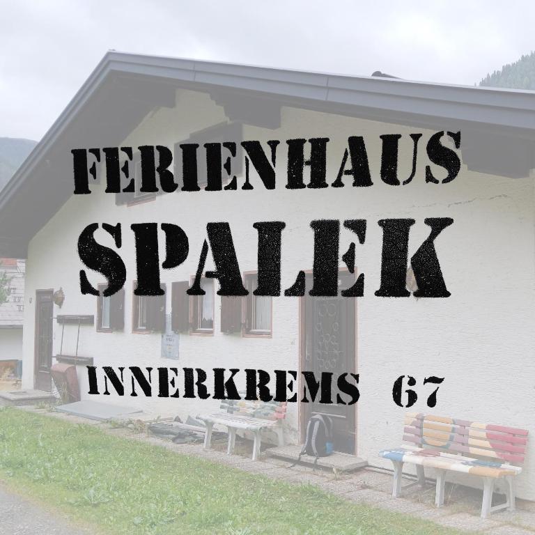 a sign on the side of a building with two benches at Ferienhaus Spalek in Innerkrems
