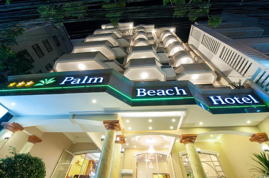 um edifício com uma placa de hotel na praia em Palm Beach Hotel em Nha Trang