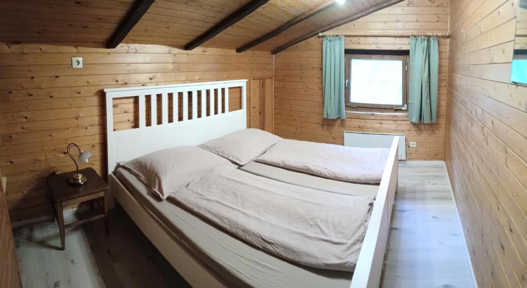 ein Schlafzimmer mit einem Bett in einer Holzhütte in der Unterkunft Ferienhaus Spalek in Innerkrems