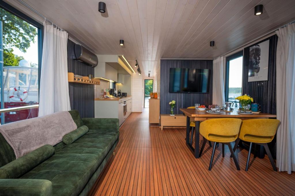 ein Wohnzimmer mit einer grünen Couch und einem Tisch in der Unterkunft Adventurous Water House Emsel Woma in Fürstenberg-Havel