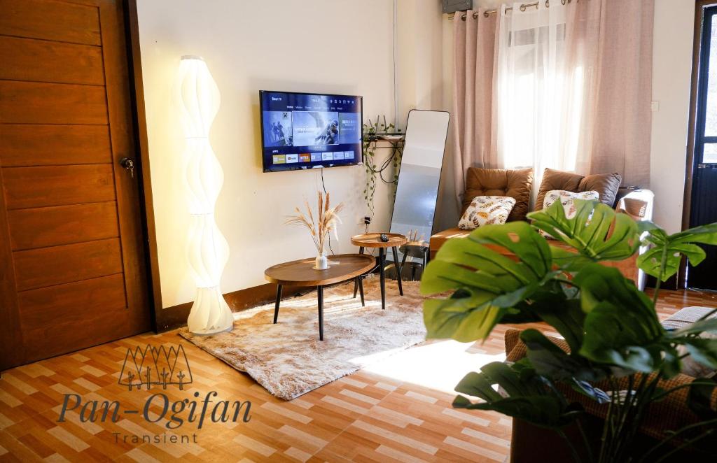 a living room with a couch and a tv at Pan-Ogifan Transient in Baguio