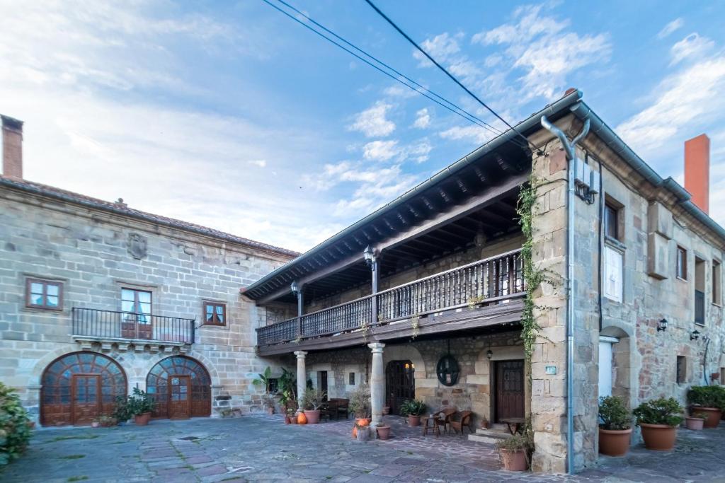 ein altes Steingebäude mit einem Balkon darauf in der Unterkunft Casa Velarde Apto 1 in Viérnoles