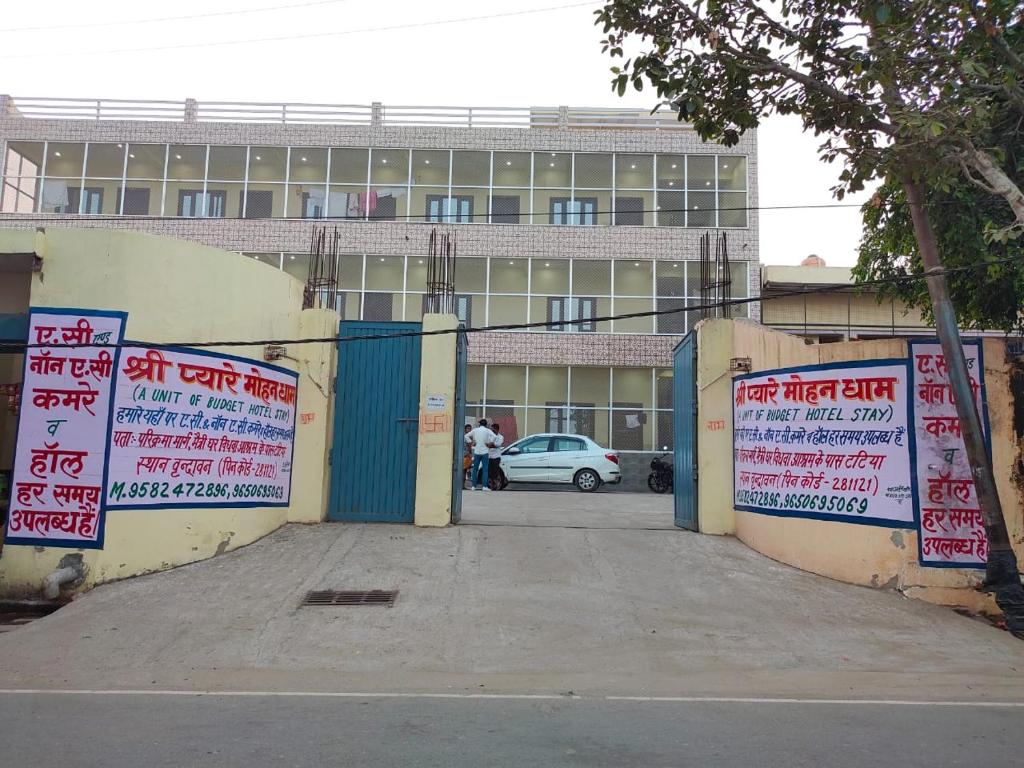 um portão com placas em frente a um edifício em Hotel Pyaremohan em Vrindāvan