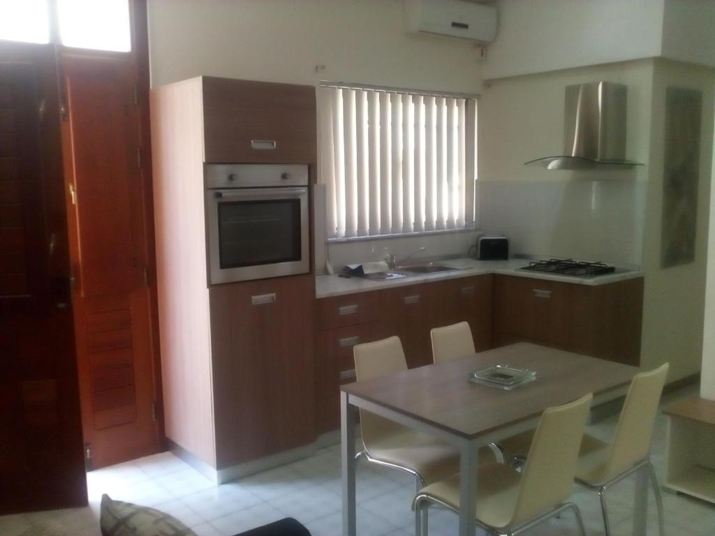 a kitchen with a table with chairs and a microwave at Private village apartment in Kirkop