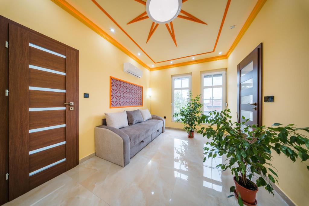 a living room with a couch and a ceiling fan at White House Apartman Miskolc, East Room in Miskolc