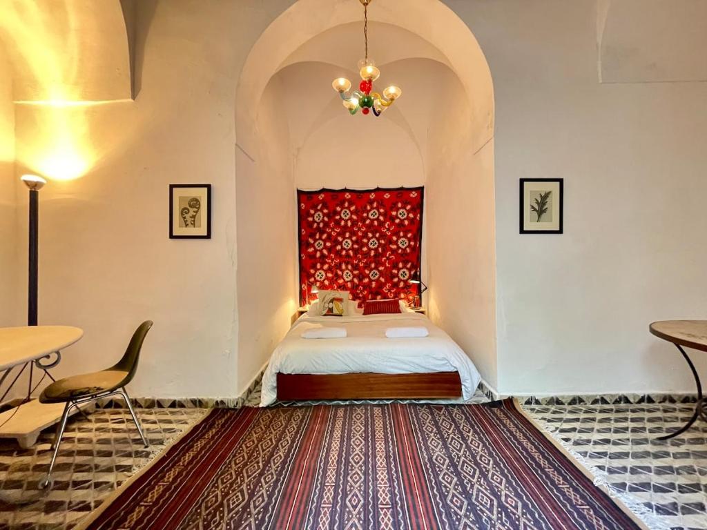 a bedroom with a bed and a red window at Suite tolila te house of medina of tunis in Tunis