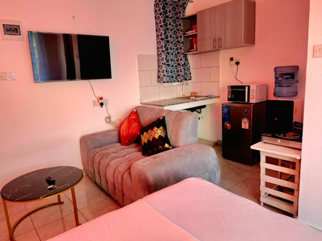 un salon avec un canapé et une cuisine dans l'établissement Sunny Escape, à Mtwapa