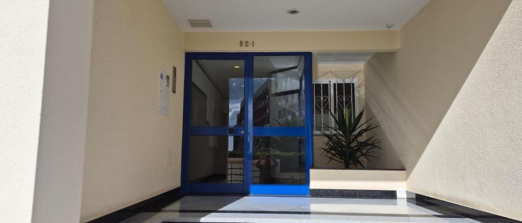a blue door in a hallway with a plant at Apartamentos Vista Mar in Armação de Pêra
