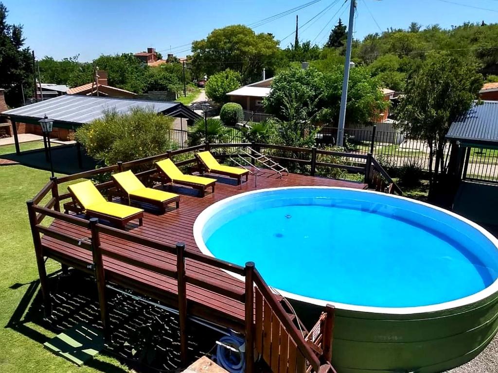 ein Whirlpool auf einer Terrasse mit gelben Liegestühlen in der Unterkunft CABAÑAS SAN ANTONIO in Capilla del Monte