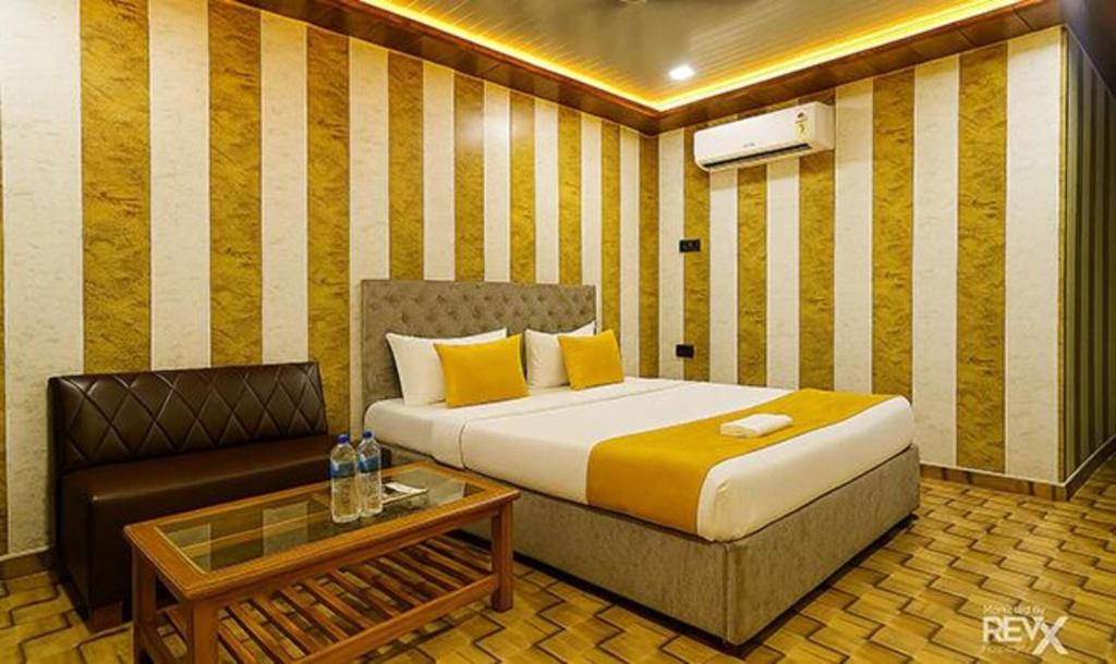 ラクナウにあるFabHotel Balajiのベッドとソファのあるホテルの部屋