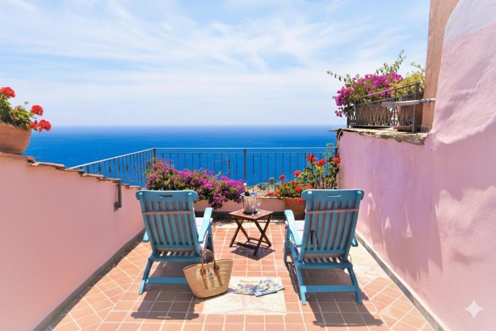 a balcony with two chairs and a table and the ocean at da Patrick in Costarainera
