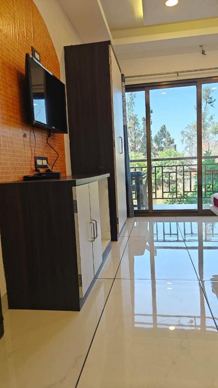 a room with a tv and a counter with a counter at Hotel Prathamesh in Panchgani