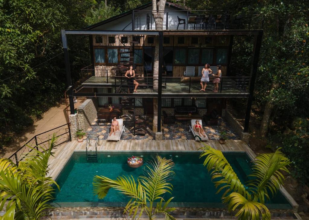 ein Haus mit Pool und Menschen, die darum herumstehen in der Unterkunft Wild Monkey Jungle Villa - 4 Bedroom Villa in Unawatuna