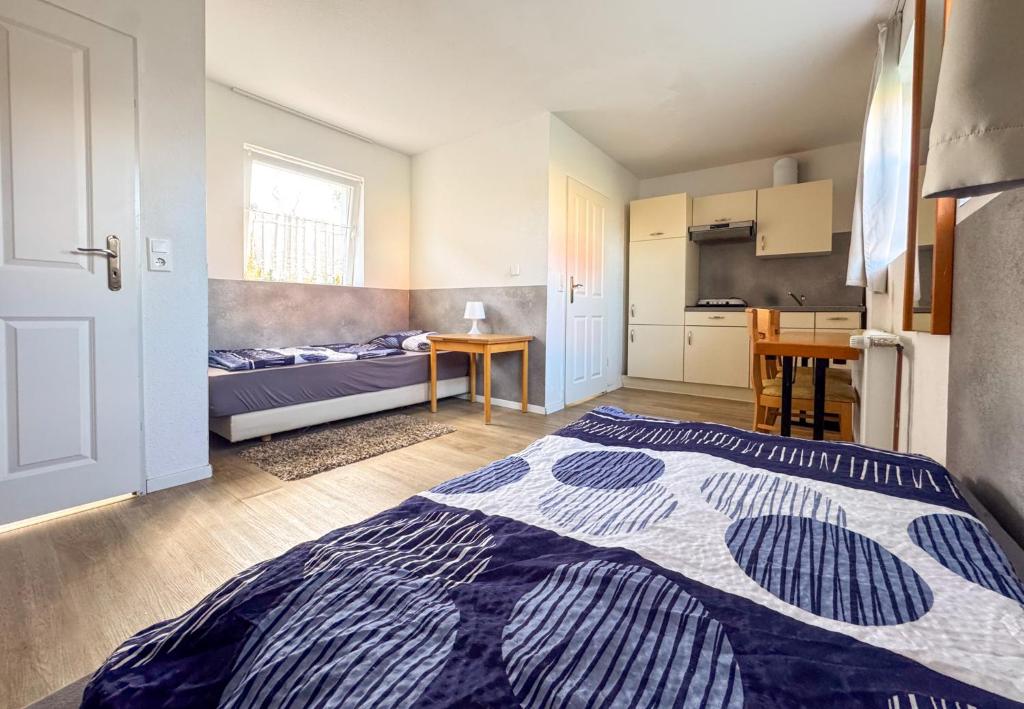 a bedroom with a bed and a table and a kitchen at Studioappartement voor 2 personen - 33-43 in Bunkenburg