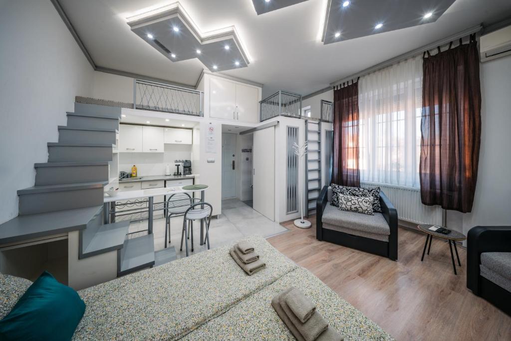 ein Wohnzimmer mit Couch und Küche in der Unterkunft Széchenyi Apartman Miskolc belvárosban in Miskolc