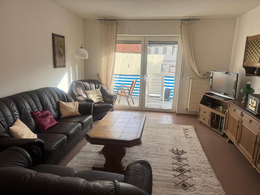 a living room with a leather couch and a table at LandgasthofOrleshausen in Büdingen